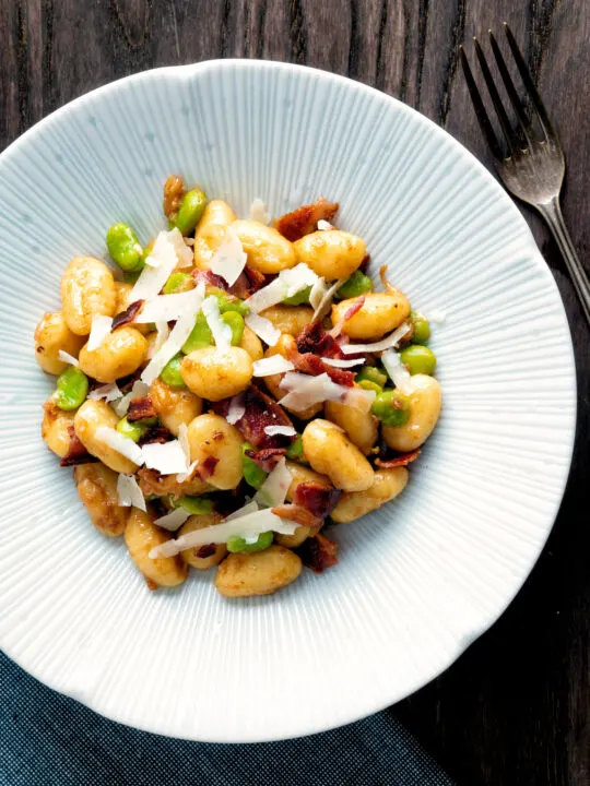 Overhead pan fried gnocchi with bacon, broad beans and parmesan shavings.