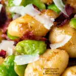 Close up pan fried gnocchi with bacon, broad beans and parmesan shavings featuring a title overlay.
