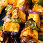 Close up paneer tikka skewers featuring a title overlay.