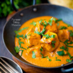 Paneer tikka masala curry served in an iron karai with naan bread featuring a title overlay.