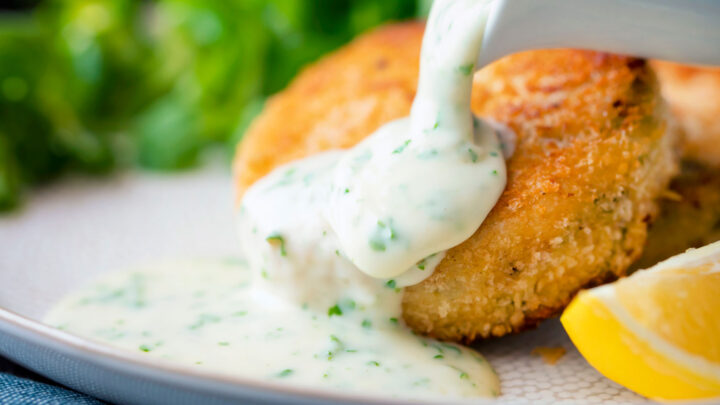 White parsley sauce poured over a fishcake.