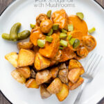 Overhead pork tenderloin stroganoff with mushrooms, fried potatoes and pickles featuring a title overlay.