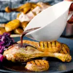 Red wine gravy poured over roast duck, with a whole duck in the background.