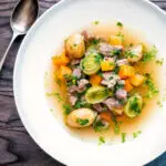 Close up Welsh cawl, a lamb and vegetable broth based soup served with bread and cheese.