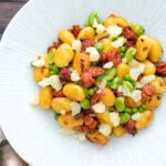 Overhead chorizo gnocchi with green peas, broad beans and manchego cheese.