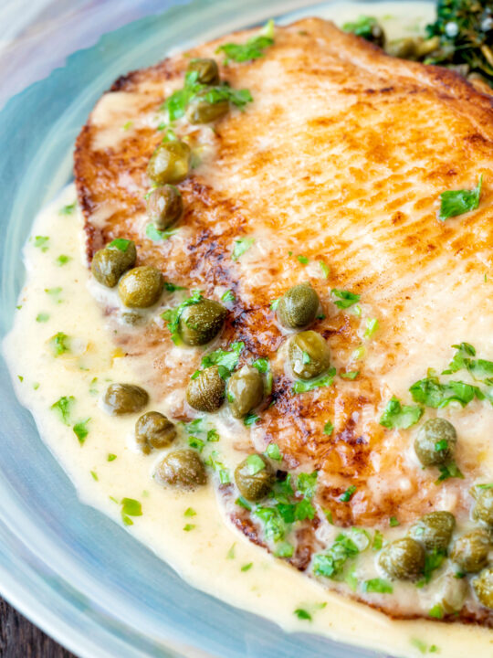 Close up pan fried skate wings served with a prosecco and caper butter sauce.