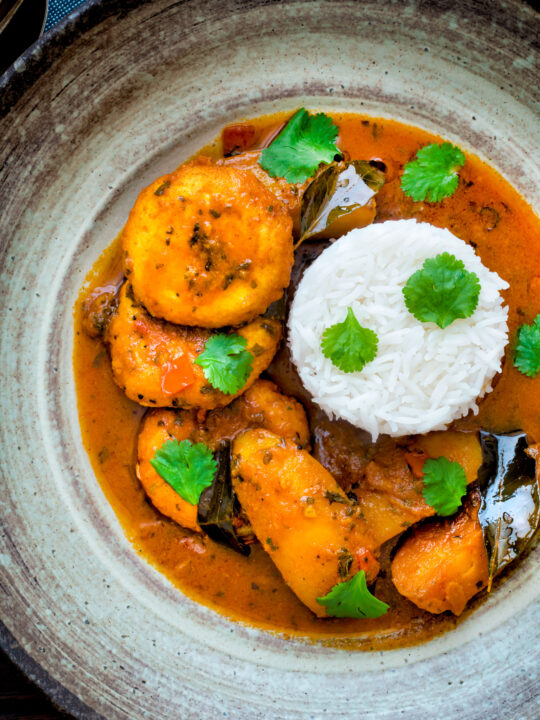 Overhead aloo paneer or chanar dalna served in a bowl with rice and coriander.