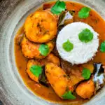 Overhead aloo paneer or chanar dalna served in a bowl with rice and coriander featuring a title overlay.