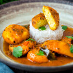 Aloo paneer curry or chanar dalna showing cut open paneer ball.