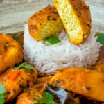 Close up aloo paneer curry or chanar dalna showing cut open paneer ball.