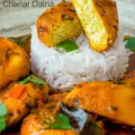 Close up aloo paneer curry or chanar dalna showing cut open paneer ball featuring a title overlay.