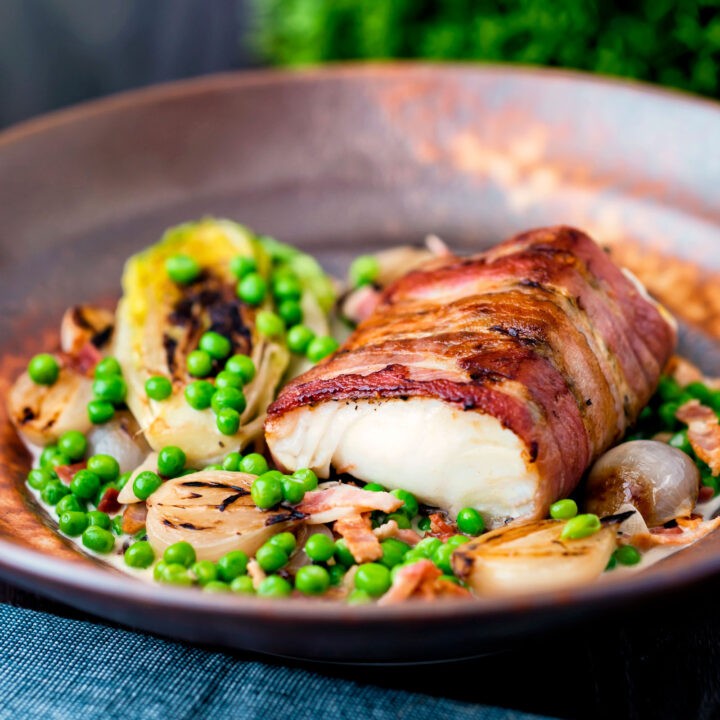 Bacon wrapped cod loin served with petit pois a la Francaise