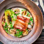 Overhead bacon wrapped cod loin served with French braised peas and lettuce featuring a title overlay.