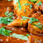Close up chicken rogan josh curry with fresh coriander.
