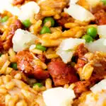 Close up chicken and chorizo risotto with green peas and Manchego cheese featuring a title overlay.