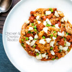 Overhead chicken and chorizo risotto with green peas and Manchego cheese featuring a title overlay.