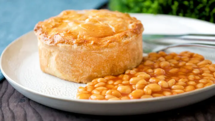 Corned beef and potato pie wrapped in shortcrust pastry served with baked beans.