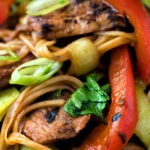 Close up hoisin pork stir fry with red peppers, onions and pak choi.