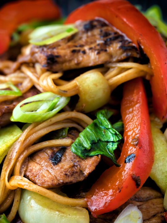 Close up hoisin pork stir fry with red peppers, onions and pak choi.