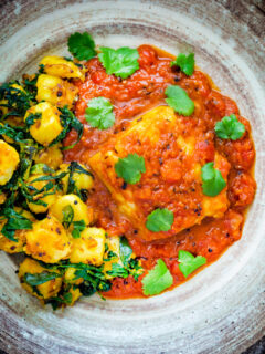 Overhead macher jhol or Bengali fish curry served with aloo methi.