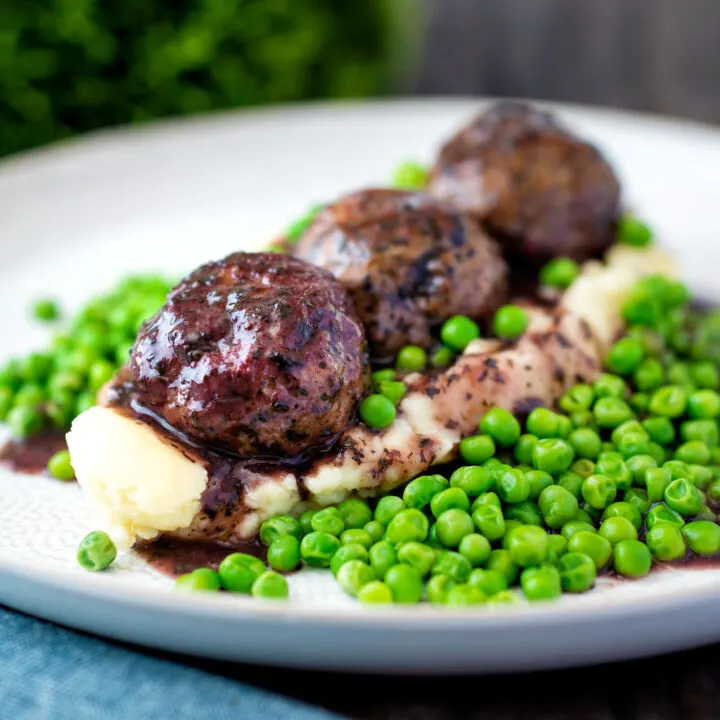 Minted lamb meatball with red wine gravy served with mashed potato and green peas.