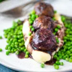 Minted lamb meatballs with red wine gravy served with mashed potato and peas.