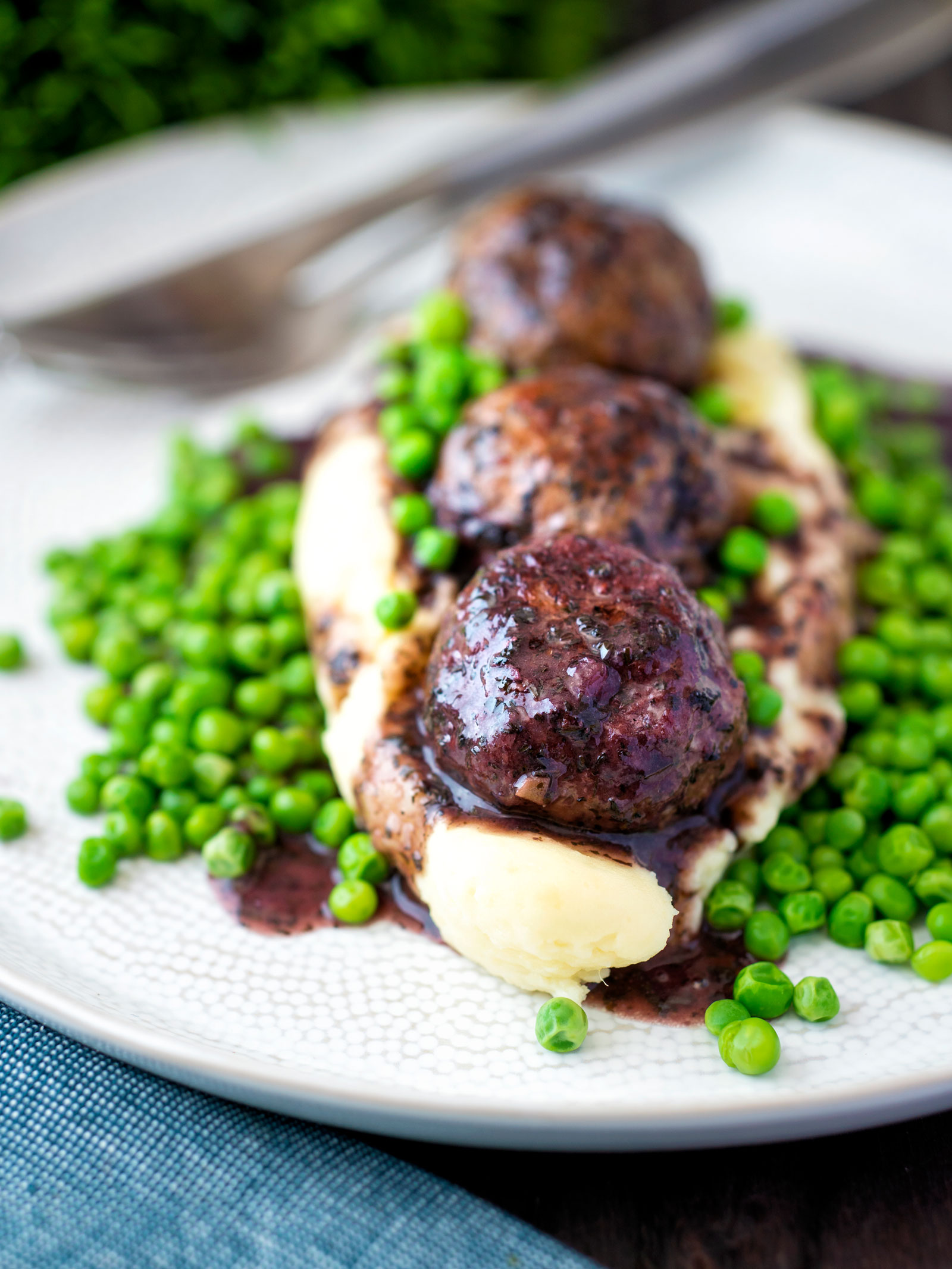 Minted lamb meatballs with red wine gravy served with mashed potato and peas.