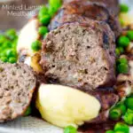 Cut open minted lamb meatball with red wine gravy served with mashed potato and peas featuring a title overlay.