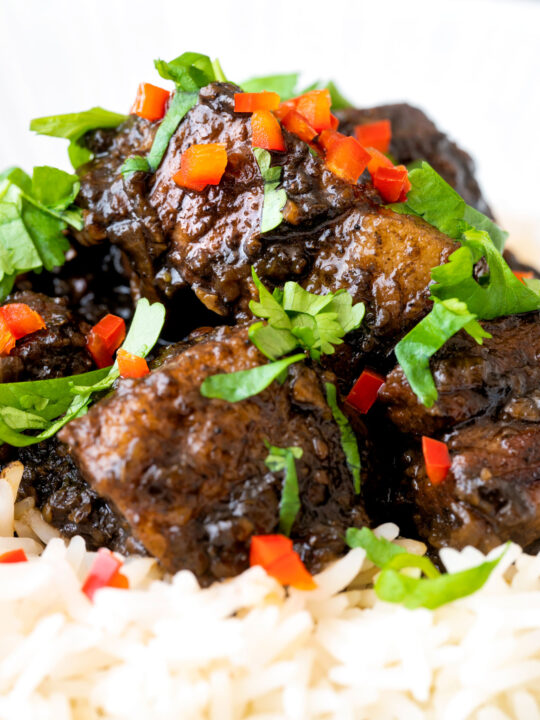 Close up babi chin Indonesian soy sauce braised pork belly served with coriander and chilli.