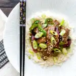 Overhead black pepper beef stir fry with green pepper and red onion.