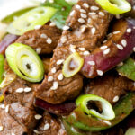 Overhead black pepper beef stir fry with green pepper and red onion.