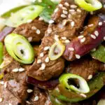 Overhead black pepper beef stir fry with green pepper and red onion.