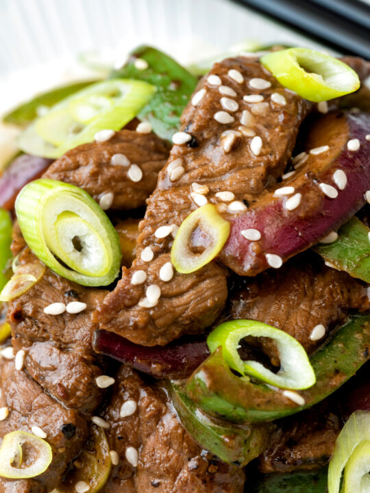 Overhead black pepper beef stir fry with green pepper and red onion.