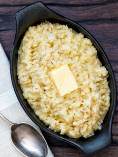 Overhead bowl of buttery celeriac mash served with an extra knob of butter.