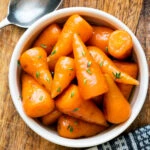 Overhead brown sugar and butter glazed Chantenay carrots with fresh thyme.
