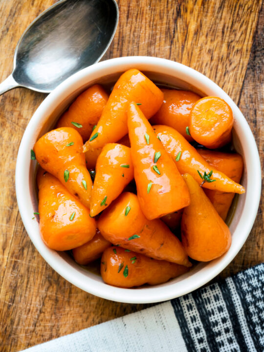 Overhead brown sugar and butter glazed Chantenay carrots with fresh thyme.