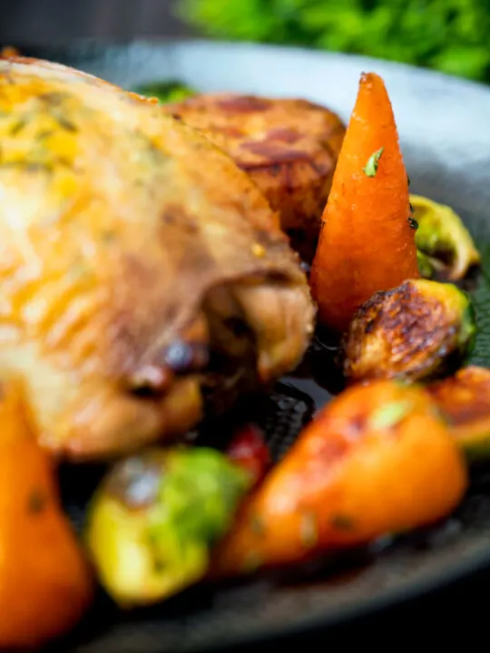 Close up brown sugar and butter glazed Chantenay carrots with fresh thyme.