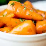 Brown sugar and butter glazed Chantenay carrots with fresh thyme featuring a title overlay.