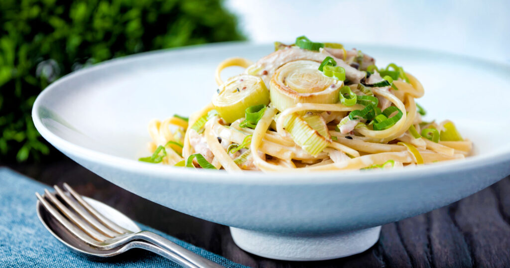 Chicken and leek pasta with linguini and shredded spring onions.