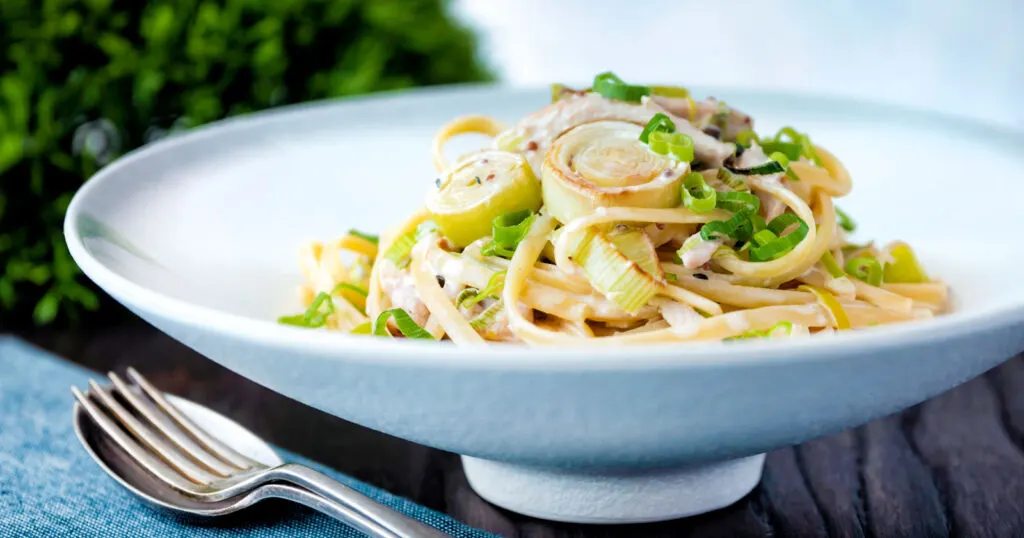 Chicken and leek pasta with linguini and shredded spring onions.