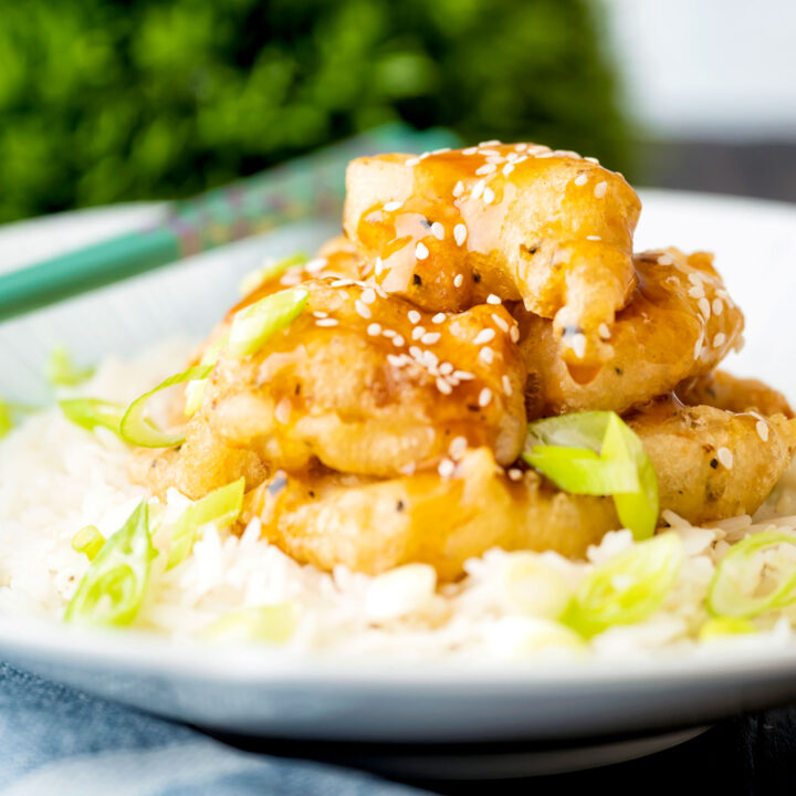 Chinese takeaway style crispy lemon chicken served with rice and spring onions.