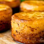 Close up fondant potatoes poached in butter and stock with a sprig of thyme.