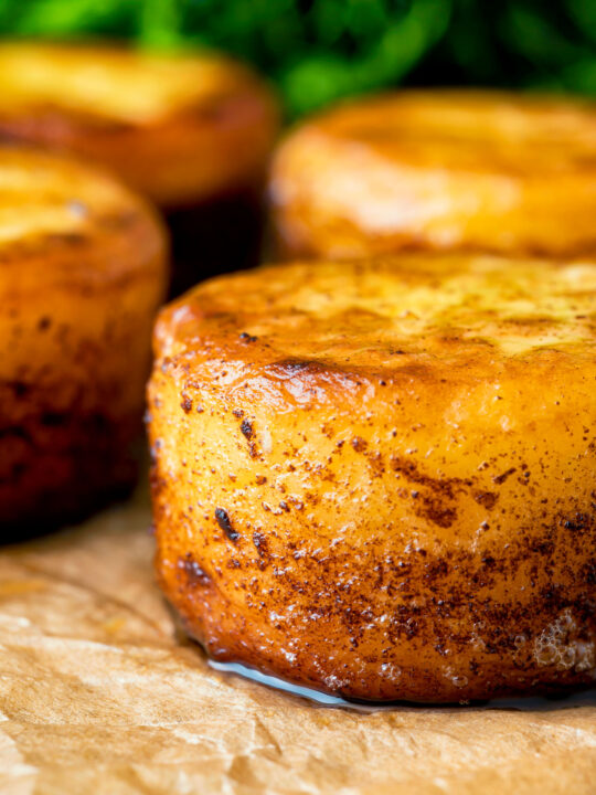 Close up fondant potatoes poached in butter and stock with a sprig of thyme.