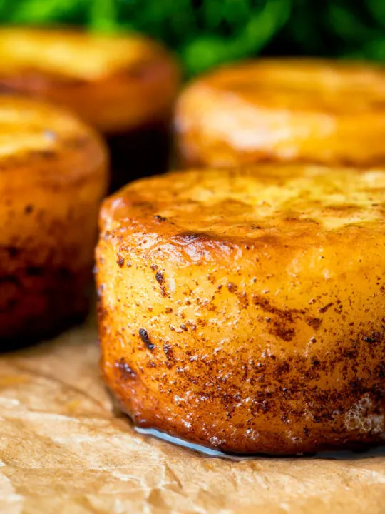 Close up fondant potatoes poached in butter and stock with a sprig of thyme.