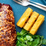 Overhead stack of fried polenta chips with green salad.