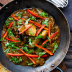 Overhead garlic chilli chicken Indian style curry served with fresh chilli and coriander.