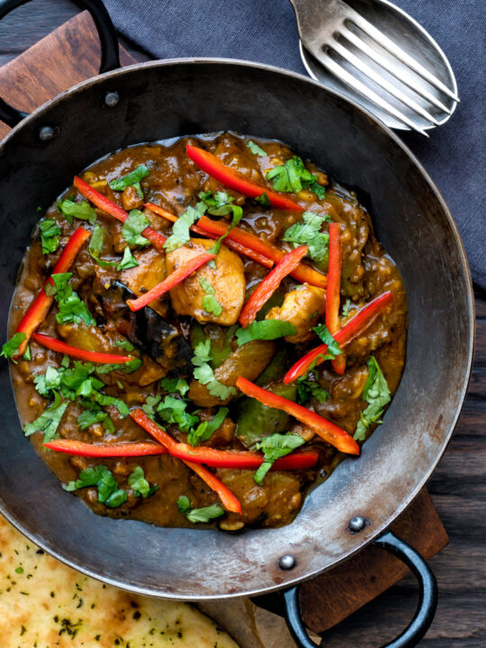 Overhead garlic chilli chicken Indian style curry served with fresh chilli and coriander.