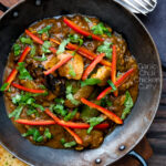 Overhead garlic chilli chicken Indian style curry served with fresh chilli and coriander featuring a title overlay.