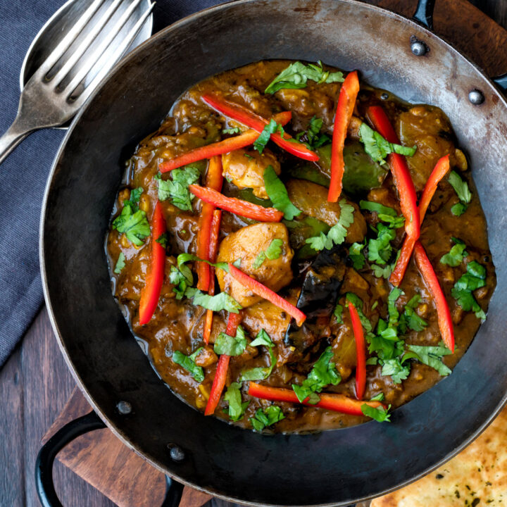 Garlic chilli chicken curry served with fresh chilli and coriander in an iron karai.