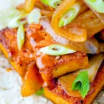 Close up Korean gochujang tofu stew with kimchi served with white rice.